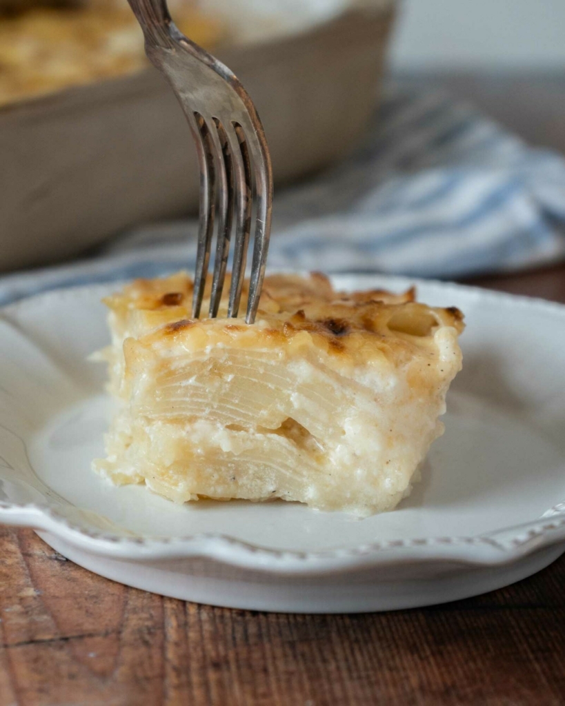 A square of potatoes au gratin sat on a white plate