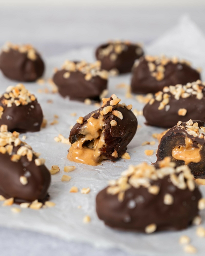Dark chocolate and peanut butter filled dates on a table