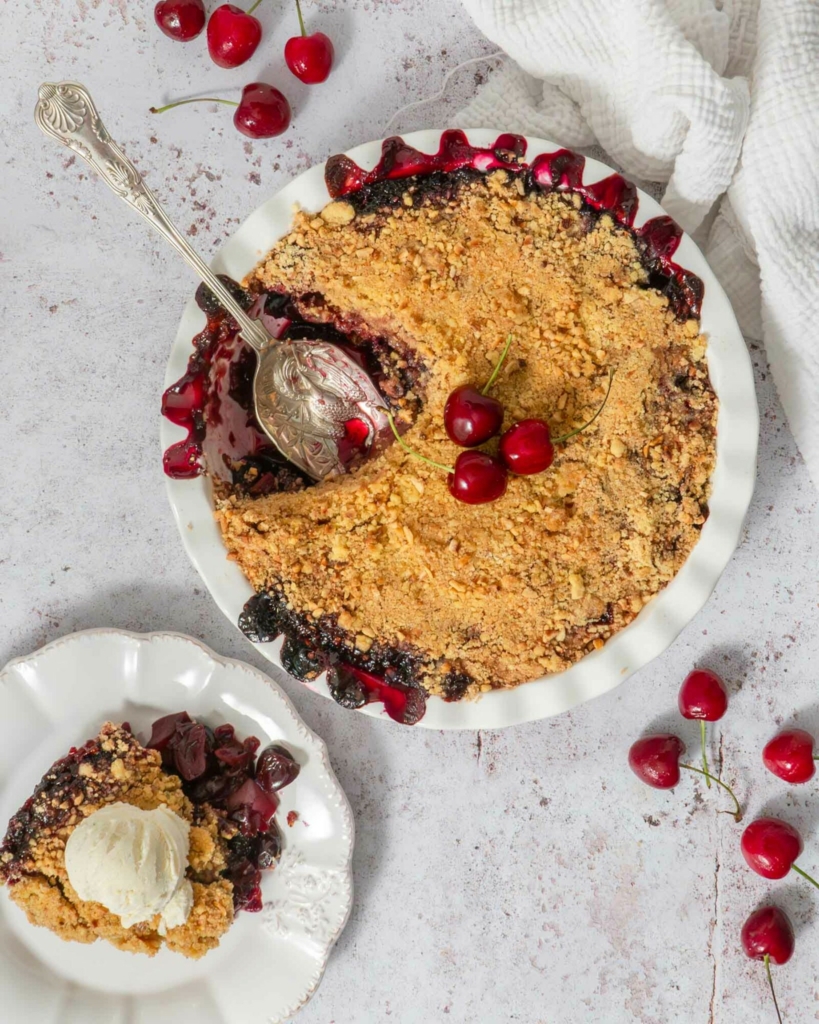 A crumble dessert being dished up on a table top