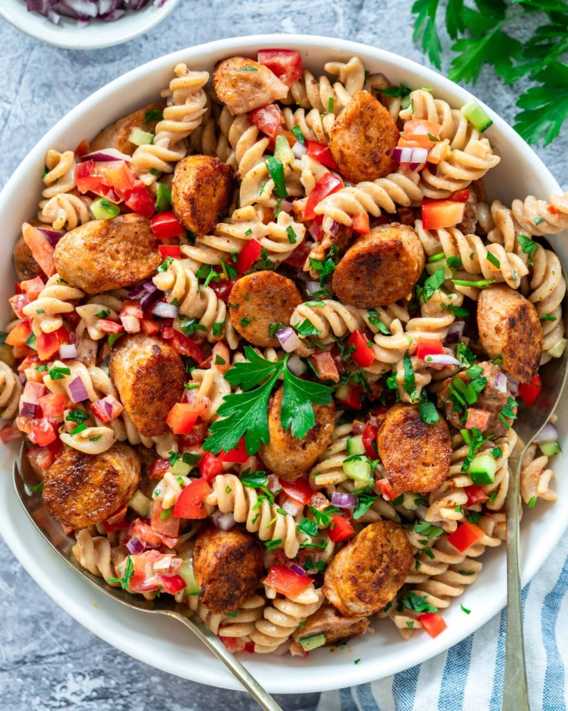 A colourful bowl of Summer Sausage Pasta Salad with crispy paprika fried sausage slices