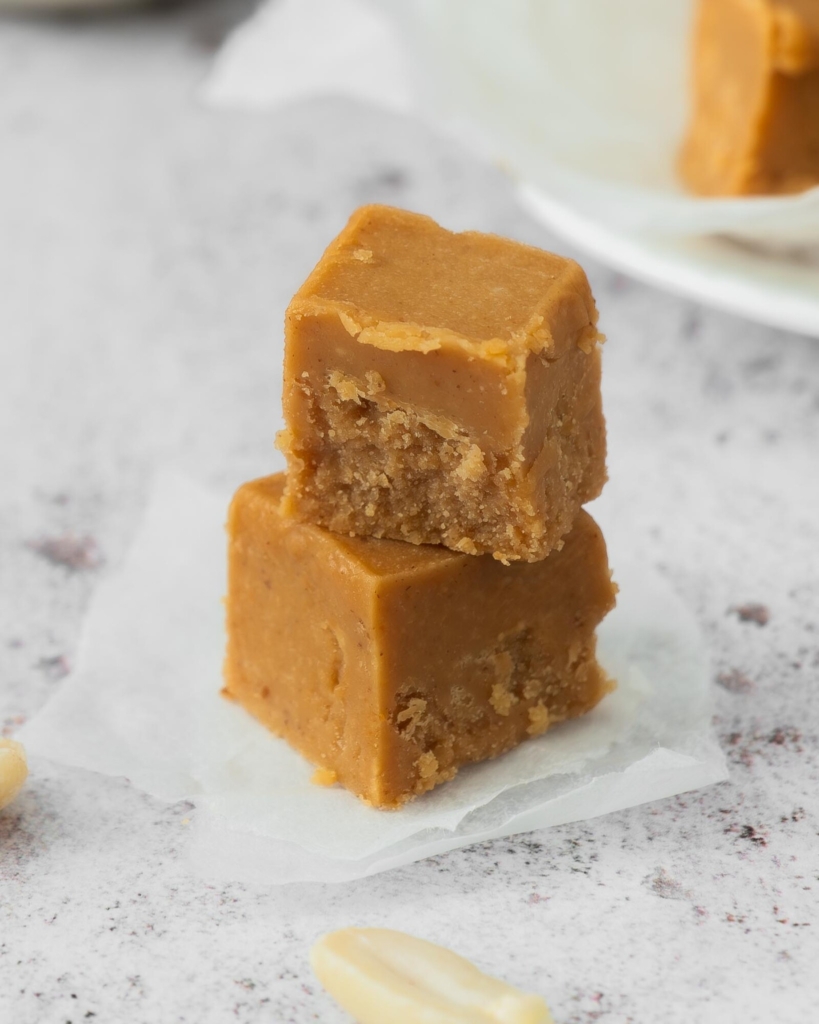 Two cubes of 3 ingredient peanut butter fudge stacked on top of each other