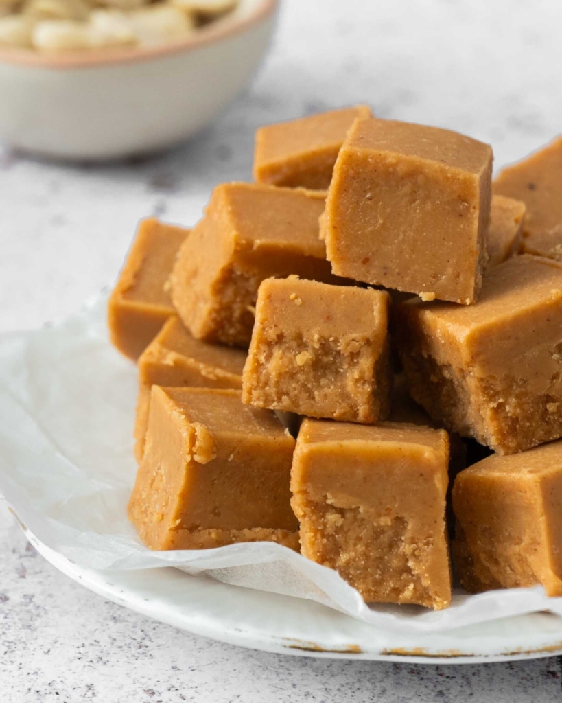 A plate stacked high with 3 ingredient peanut butter fudge no milk