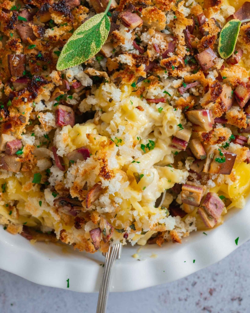 A baking dish filled with creamy dairy free mac and cheese with a crispy vegan bacon breadcrumb topping