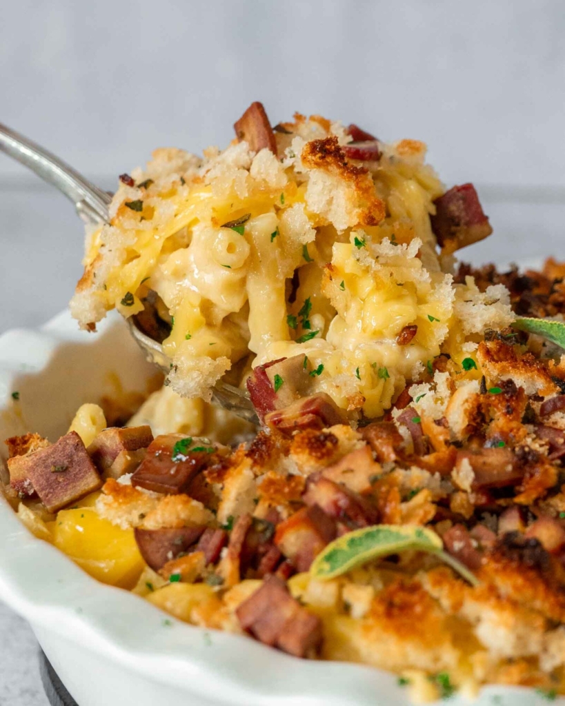 A large spoonful of creamy dairy free mac and cheese with a crispy vegan bacon breadcrumb topping