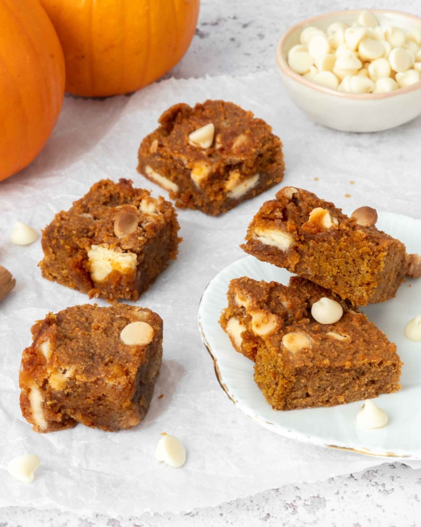 Vegan chickpea blondies next to some mini pumpkins