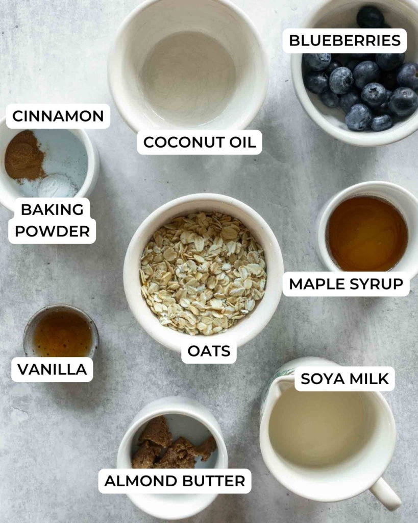Ingredients laid out in bowls ready to make vegan baked oatmeal for one with fresh blueberries