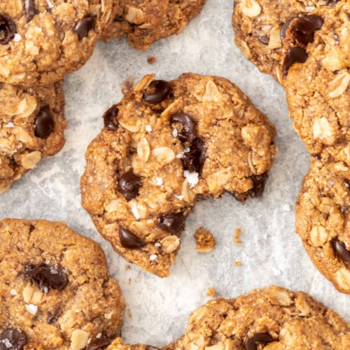 Up close image of a dairy free oatmeal chocolate chip cookie with a bite taken out of it