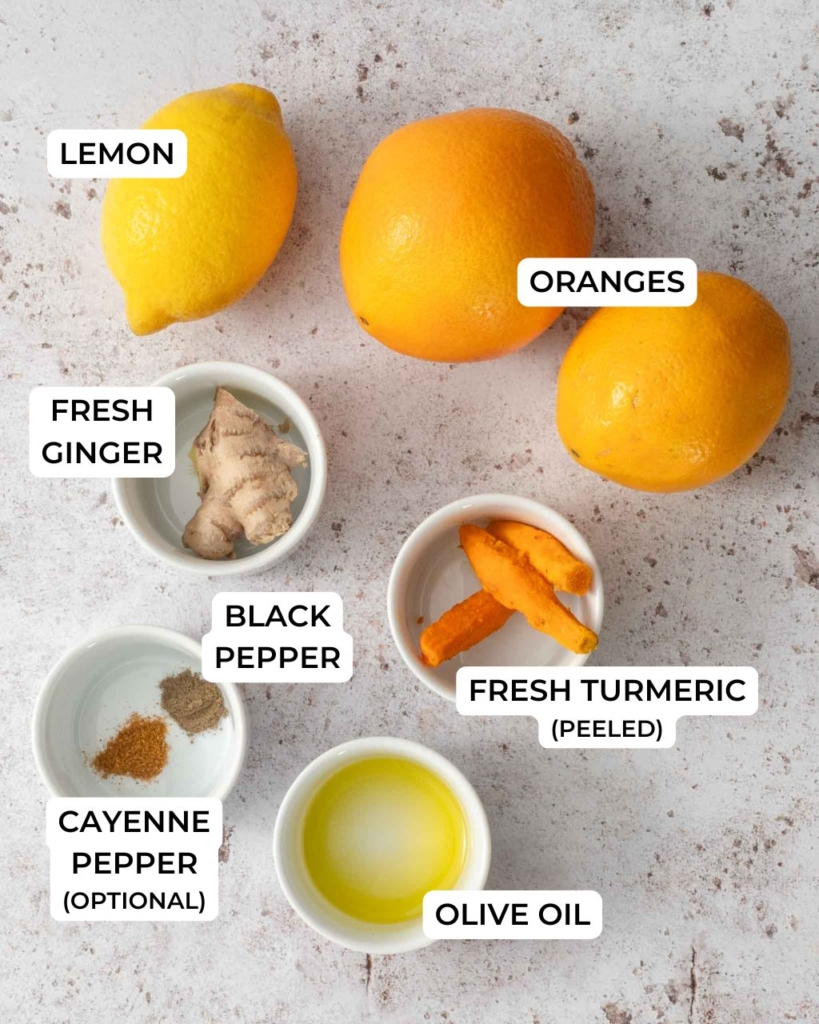 The ingredients needed to make a ginger turmeric juice shot, laid out on a table top