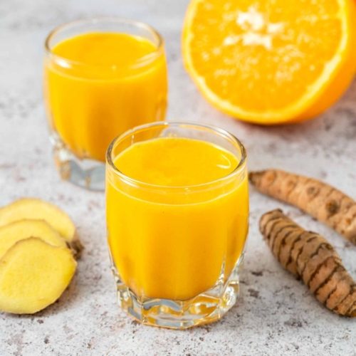 Two fresh, bright ginger turmeric shots