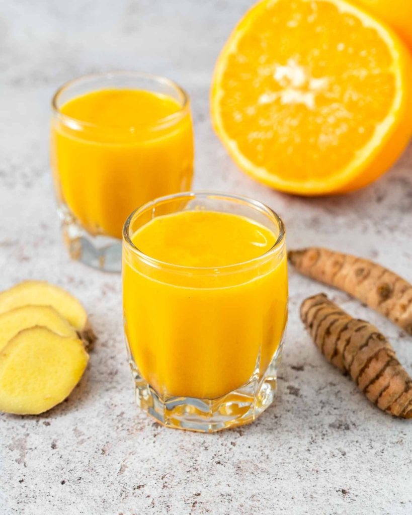 Two fresh, bright ginger turmeric shots