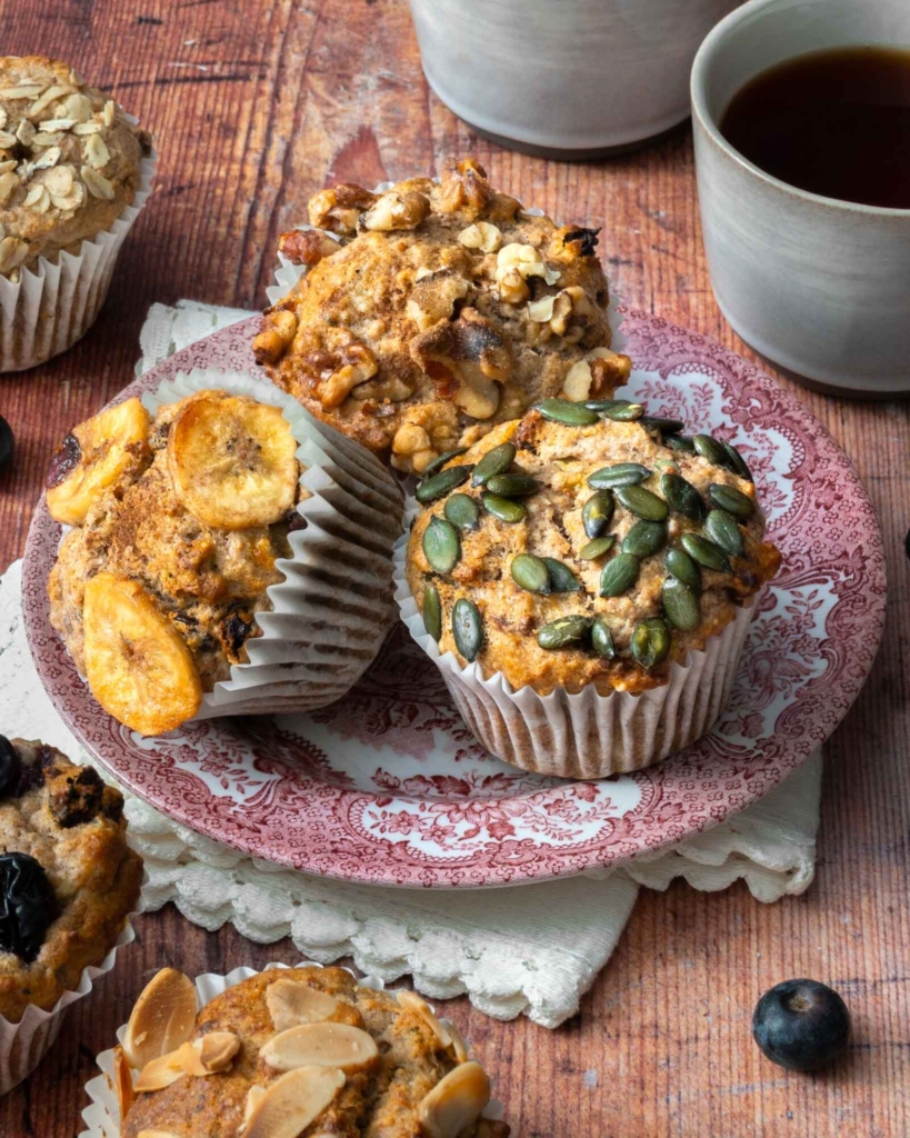 Sugar free breakfast muffins on a vintage plate, topped with seeds, fruit and nuts