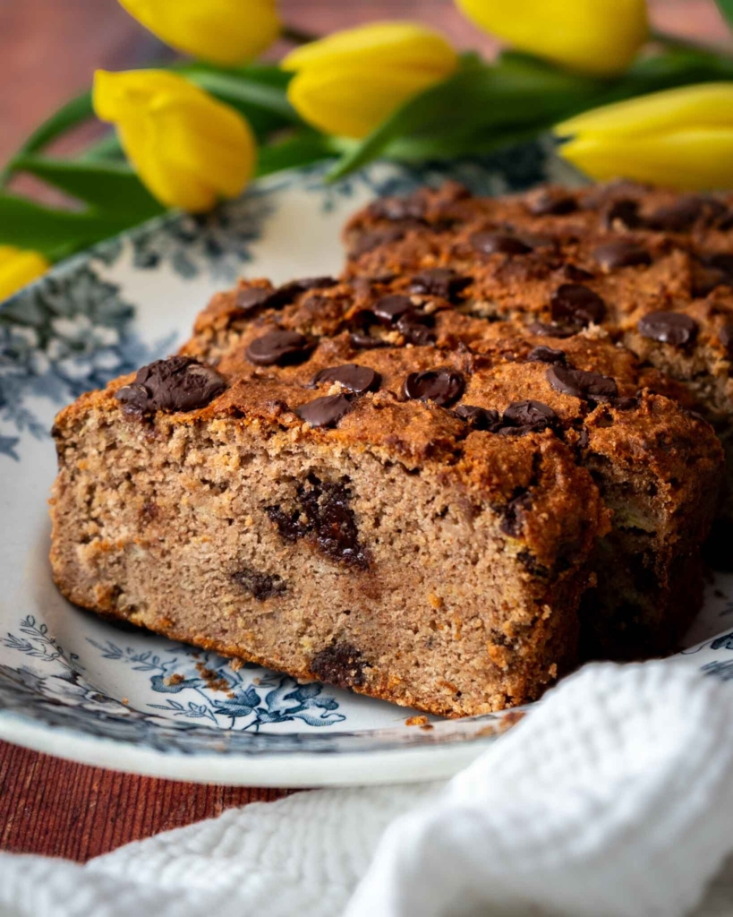 Slices of golden chocolate chip buckwheat banana bread on a vintage plate