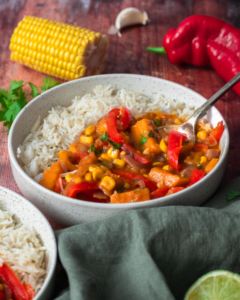 A colourful sweet corn, squash and red pepper curry in a bowl