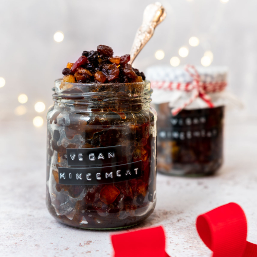 A jar of vegan mincemeat without suet with twinkly bokeh Christmas lights in the background