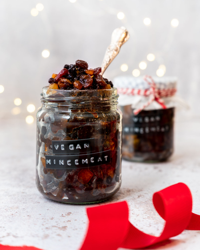 A jar of vegan mincemeat without suet with twinkly bokeh Christmas lights in the background
