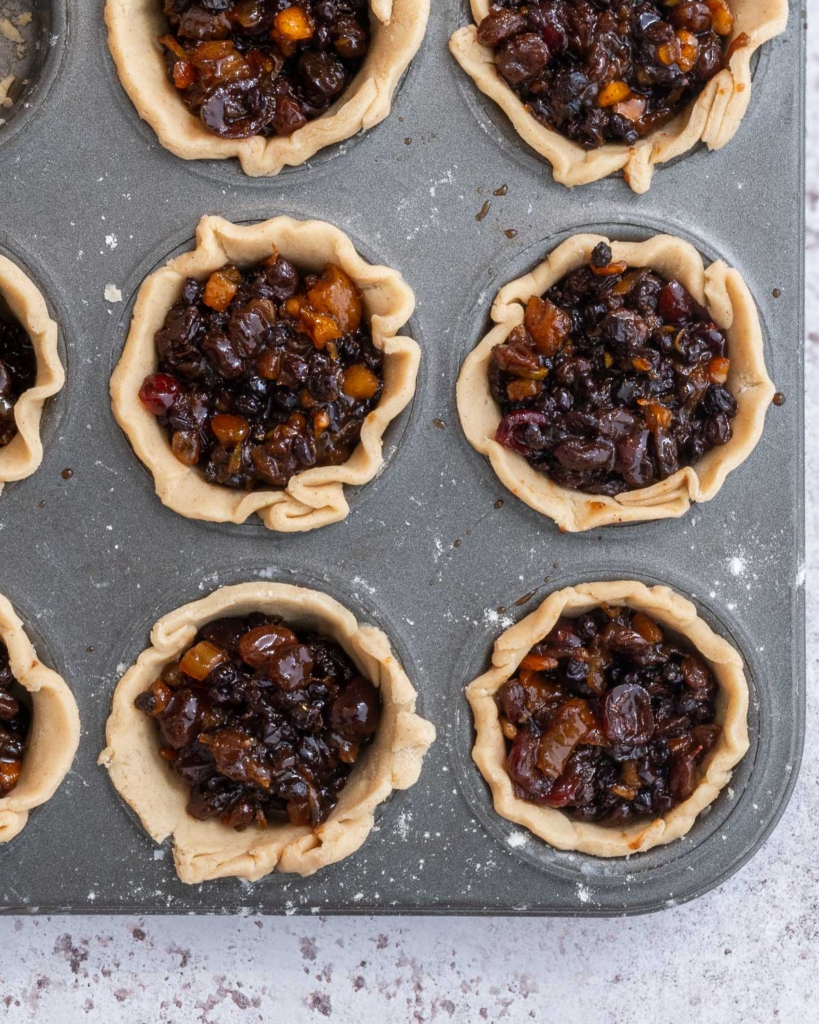 A muffin tray filled with buttery vegan pastry cases and juicy mincemeat without suet